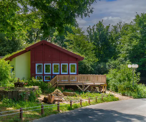 Das Naturschutzhaus liegt ruhig am Rand einer bewachsenen Fläche.