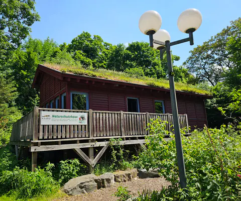Der Eingang des Naturschutzhauses und ein Schild sind gut sichtbar.