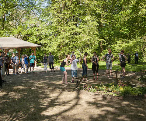 Eine lebendige Gruppe beim Bogenschießen im Grünen.