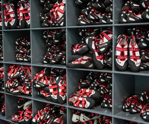 Kletterschuhe stehen auf dem Boden neben der Wand.