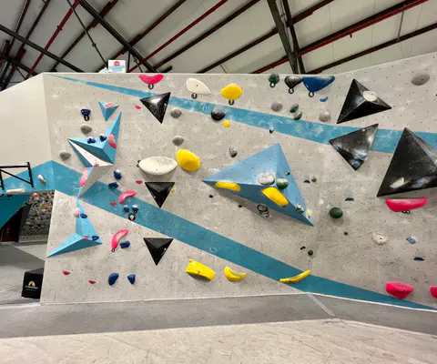 Eine Boulderwand mit klar erkennbarer Struktur und großen Griffen.