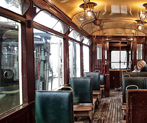 Der Innenraum einer historischen Straßenbahn mit klarer räumlicher Wirkung.