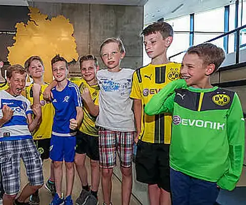 Eine Gruppe von Kindern steht lachend im Innenraum.