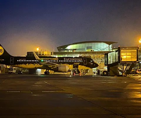 Flugzeug und Terminal bei Nacht auf dem Flughafengelände