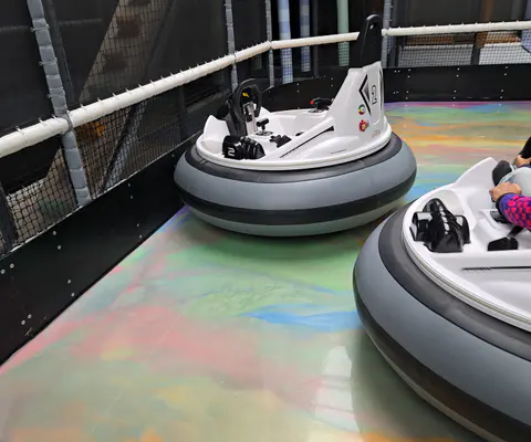 Bumper Cars in einer Innenhalle mit farbigen Fahrzeugen.