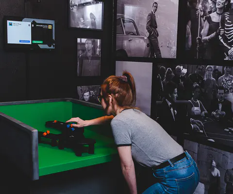 Eine Person steht an einer Spielstation und ist mitten in der Aktion.