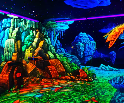 Schwarzlicht-Minigolfraum mit leuchtenden Farben und klarer Bahnszene.