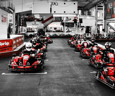 Mehrere Karts fahren dynamisch durch eine Kurve auf der Strecke.