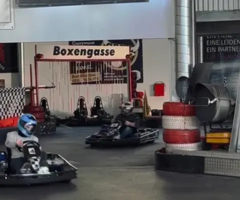 Ein Kart fährt auf der Strecke in einer engen Innenkurve.