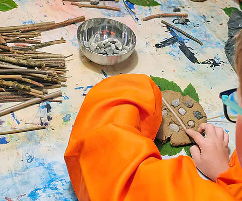 Kinder gestalten gemeinsam eine kreative Mitmachstation im Museum.