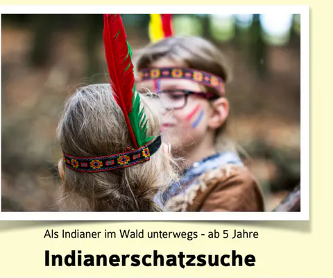 Zwei Kinder mit Federschmuck stehen sich im Wald gegenüber.