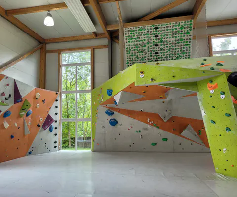 Große Kletterhalle mit zahlreichen Routen und weitem Hallenraum.