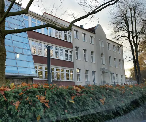 Das Gebäude steht bei Tageslicht von außen sichtbar vor dem Eingang.
