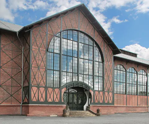 Die Maschinenhalle von außen mit markanter Architektur.