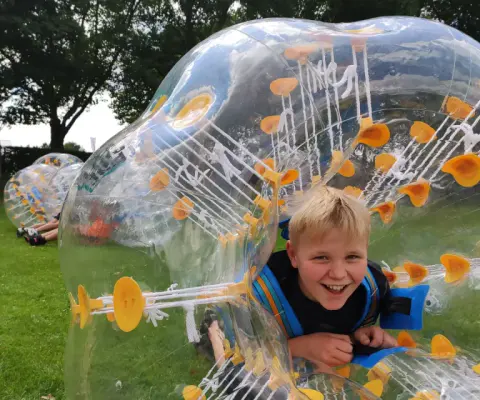 Fröhliche Kinder feiern einen Geburtstag beim Spielen und Toben.