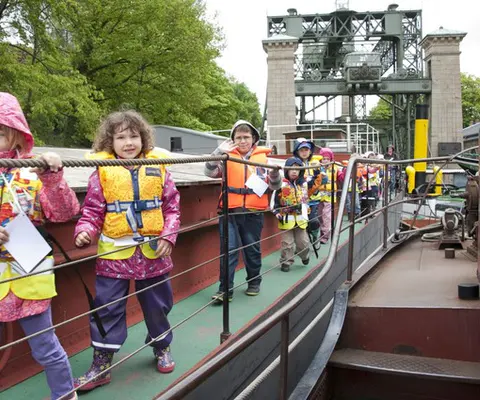 Kinder in Schwimmwesten stehen auf dem Deck des Museumsschiffs.