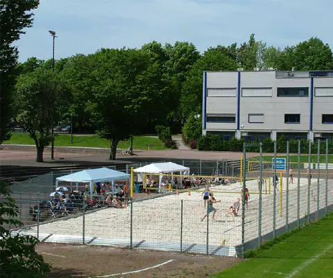 Kinder nutzen eine Sportfläche in einem weiten Innenraum.